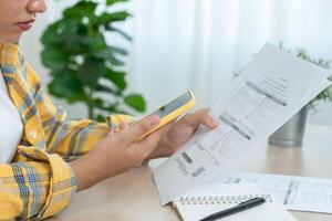 women use phone scan barcode or QR codes to pay credit card bill after receiving document invoice. payment, receive, paying electricity, digital payments, technology, scanning, financial transactions photo