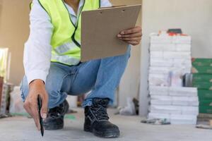 inspector engineer inspecting construction and quality assurance new house using a checklist. Engineers or architects or contactor work to build the house. photo