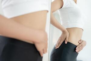 Women show results of diet. Beautiful shape. female look mirror for check shape body have a reduced waist size after under going a weight loss corse. balance, control, routines, exercise photo