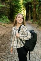 A Young Hiker Smiling Happily While Enjoying a Beautiful Forest Trail in Natures Embrace photo