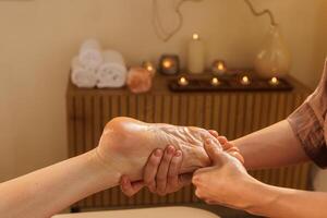 Close-up of a professional foot massage in a tranquil spa setting with oil, focusing on pressure points to relieve tension, enhance circulation, and promote full-body relaxation. photo