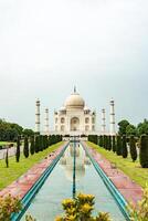 Taj Mahal reflecting in the water pool in Agra, India photo