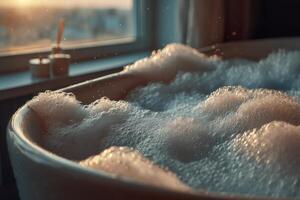A bubble bath filled with soft white foam captures warm light from the sunset, creating a serene atmosphere in a stylish bathroom photo