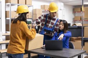 Employees group in a supply room prepares merchandise and boxes with tracking numbers and air waybills. The local brand offering express delivery and custom orders management. photo