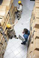 Industrial warehouse staff supporting supply chain process to organize products on racks and prepare them for distribution in a highly functional logistics center. Quality control in depot. photo