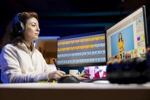 Photographer using advanced photo editing software and listening podcasts. Photo editor utilizing specialized photographs retouching application to make adjustments, hearing songs in headphones