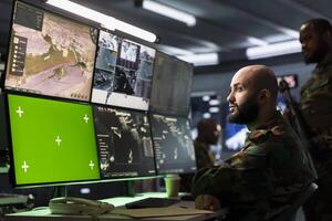 Counterterrorism division operative using target acquisition tech on isolated screen gear to detect enemy location. Defense security expert using chroma key satellite hardware to track threats photo