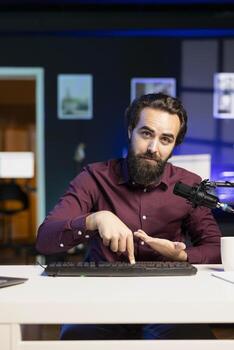 Man filming keyboard disassembly guide doing tutorial on how to do maintenance. Technology internet show host teaching subscribers how to clean and fix individual keyboard keys photo