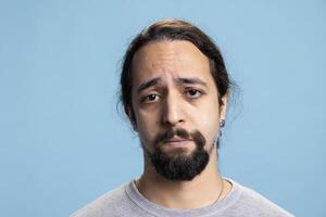Disappointed sad tired guy feeling distressed and discouraged on camera, dealing with low self esteem and emotional crisis. Depressed unhappy person suffers from anxiety or grief. photo