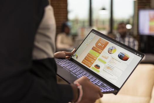 africano americano hombre analizando Estadísticas en ordenador portátil pantalla, trabajando con financiero gráficos y cartas en línea. de cerca de empleado utilizando negocio software para datos análisis y proyecto gestión. foto