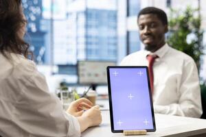 Recruiter using isolated screen tablet doing interview with person after finding best talent to fill open company position. HR department employee using mockup device, finalizing deal with man photo