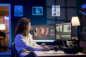 producer adds sound effects to film montage, working in studio. Videographer using headphones to test and improve audio quality using specialized software on computer photo