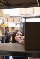 Asian female staff at a small business supply room handles merchandise and prepares shipments, ensuring local delivery. Local brand operations include express delivery, inventory tracking. photo
