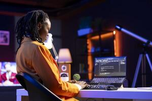 Freelancing admin in home office using laptop to write programming language code. Young software technician working from apartment using notebook device to build application photo