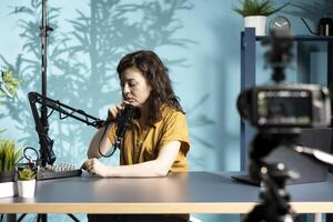 Content creator positioning professional microphone closer, ensuring it captures clear audio for upcoming . Vlogger checks audio levels, making slight adjustments to balance sound photo