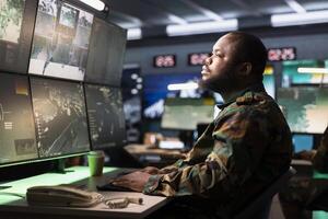 Air defense command operator using radar systems to detect incoming ballistic missiles. Army soldier in base of operations scanning rockets approaching borders, deploying shields photo
