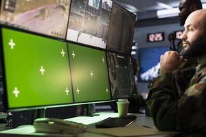 Air defense operative using radar on green screen equipment to detect ballistic missiles. Army soldier scanning rockets approaching borders using chroma key satellite hardware, deploying shields photo