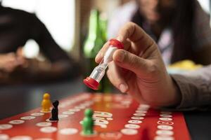 Selective focus on male individual setting hourglass timer for board game. Closeup shot capturing playful nature of game and adds sense of time management to friendly competition. photo