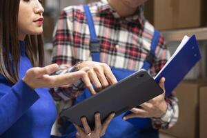 Team of employees in a small business warehouse prepares packages for local delivery. Packed boxes at a shipping station waiting to be shipped, efficient order processing and fulfillment. photo