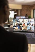 African American professional collaborating online with remote colleagues during videoconference. Black female financial advisor using laptop, attending a virtual meeting with startup company team. photo