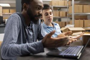 Team of diverse people checking logistics for order processing tasks and express delivery, working in a distribution hub supply room. Working on product handling for local brand. photo