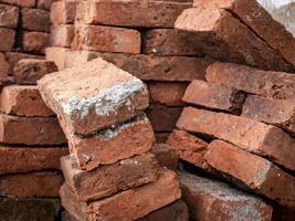 red bricks arranged crookedly with white cement stains on one side photo