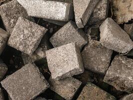 The paving block that will be used for paving the yard are stacked roughly photo