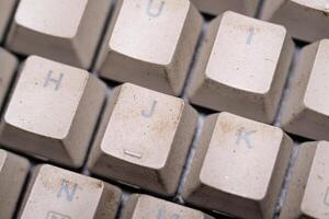 Close-up shot of square key caps in gray and black. Macro Photography of mechanical keyboard with two unique and cool colors. Dirty keycaps with dirt and crust closeup. Technology Backgrounds photo