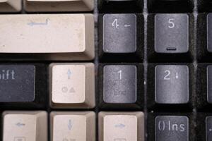 Close-up shot of square key caps in gray and black. Macro Photography of mechanical keyboard with two unique and cool colors. Dirty keycaps with dirt and crust closeup. Technology Background photo