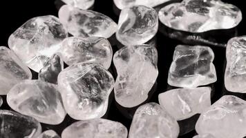Clear quartz stones displayed on a black surface with bright lighting, highlighting their transparency and texture video