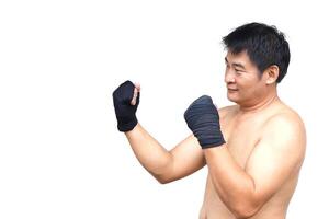 A confident Thai male boxer prepares for training with black hand wraps in a traditional fighting stance, isolated on white background. Concept, art of Muay Thai as a powerful self-defense practice. photo