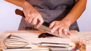 Person chopping chocolate discs with a knife video