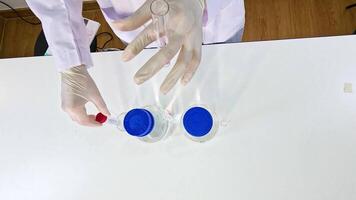 Hands in gloves conduct a chemical experiment with potassium permanganate, showcasing color change in a lab setting video