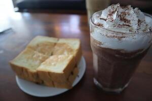 A glass of chocolate milk and a slice of bread photo