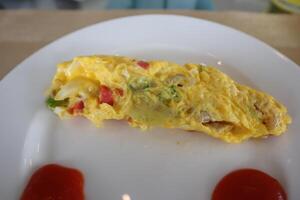A plate with an omelet and some ketchup on it photo
