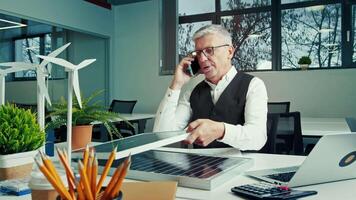 Professional Discusses Renewable Energy Solutions While Reviewing Solar Panel Designs in Modern Office Setting video