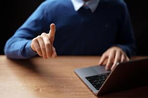 Individual gestures while using a laptop during a virtual meeting at home in the evening photo