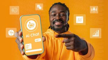 Young man showcasing AI chat application on smartphone with vibrant orange background in a tech-focused environment photo