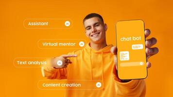 Young man shows smartphone displaying chatbot features against a bright orange background in a modern workspace photo