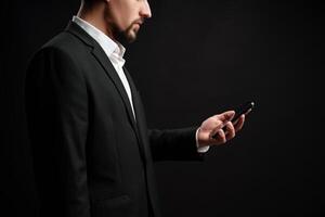 Professional man checking his smartphone while dressed in formal attire against a dark background photo