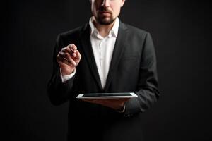 Business professional using a tablet in a dark studio for digital strategy and presentations photo
