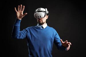 Man interacts with virtual reality technology in a dark studio setting experiencing immersive digital environments photo