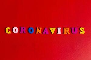 Pandemic and virus concept. Coronavirus word made of colourful blocks. Coronavirus text on red background. Coronavirus concept top view photo