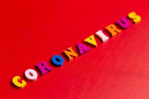 Pandemic and virus concept. Coronavirus word made of colourful blocks. Coronavirus text on red background. Coronavirus concept top view. photo