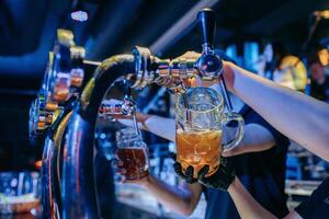 Bartender pouring beer at the bar. Close up hands. photo