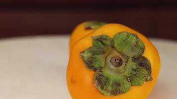 Two persimmons resting on a table video