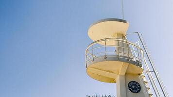 White lifeguard tower stands near palm trees in Alicante, Spain. Image suitable for beach safety, tourism, or coastal architecture context. photo