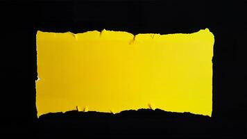 Rectangular yellow torn paper with rough edges isolated on a solid black background. Suitable for design, presentation, or creative project requiring a bold, isolated paper element. photo