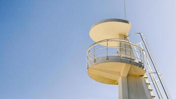 White lifeguard tower on blue sky as a background. Image suitable for beach safety, tourism, or coastal architecture context. Copy space for text. photo
