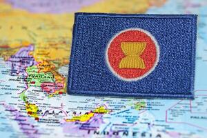AEC flag, ASEAN flag made from eco-endly stitched fabric, laid over a world map centered on Southeast Asia. Concept of unity, international cooperation. Captured on June 13, 2025, Thailand. photo